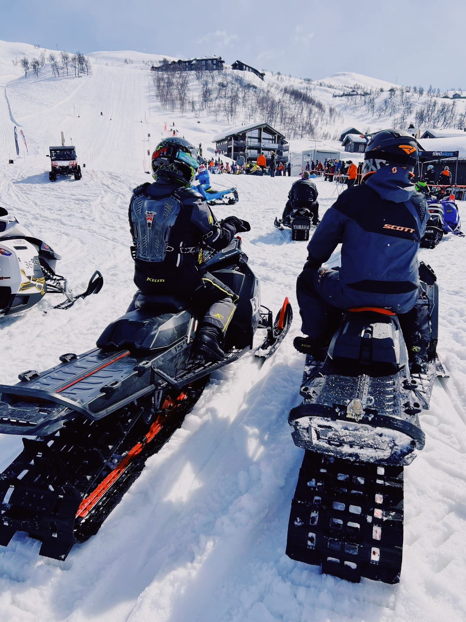 To snøscootereførere som ser opp skibakken på Haukelifjelll